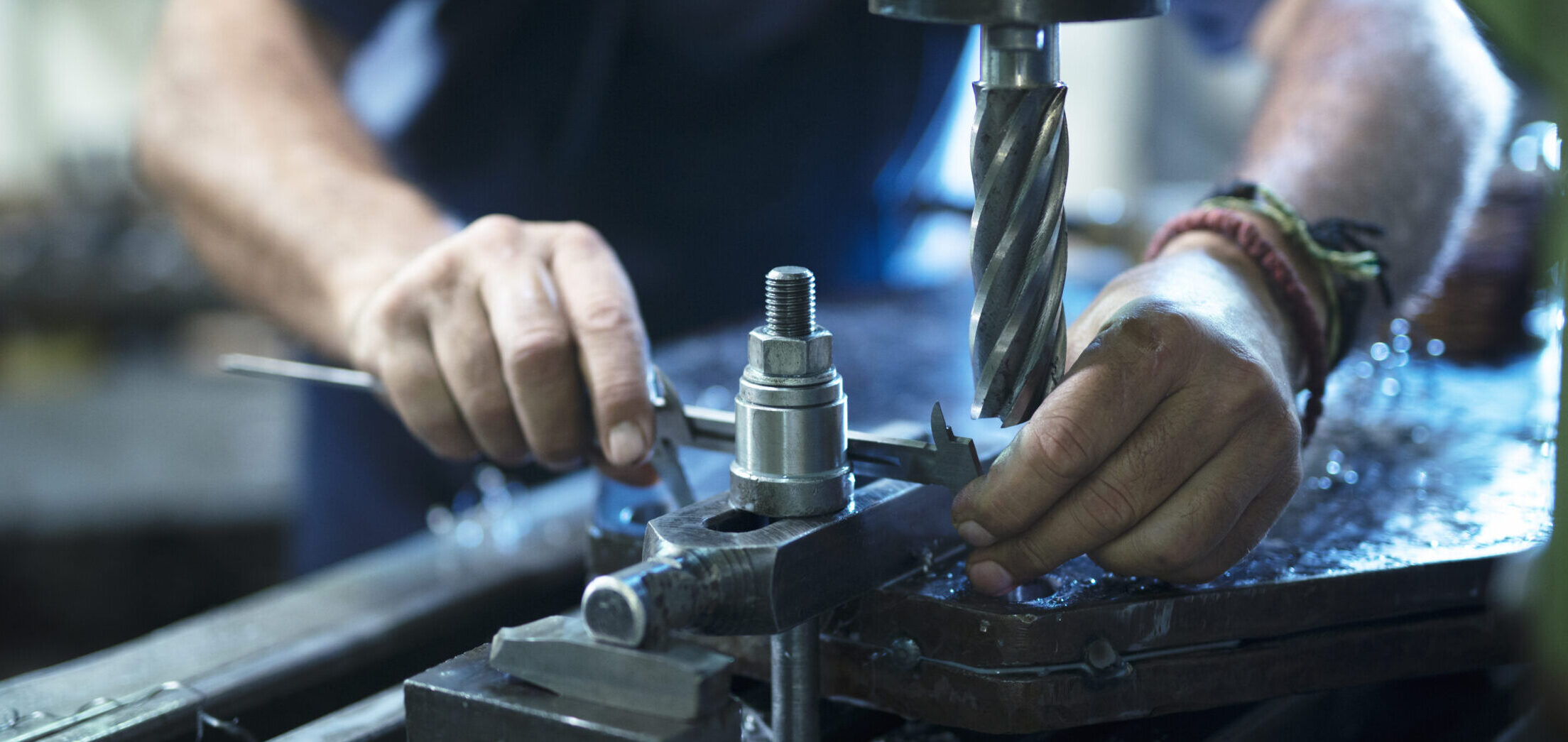 worker operating industrial machine in metal workshop.